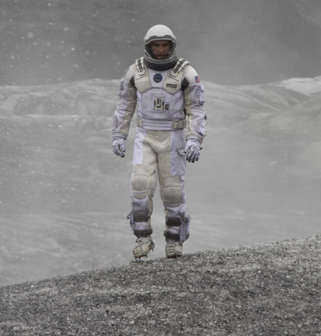 Ator de interestelar, vestido com roupa de astronauta em um cenário esbranquiçado de neve